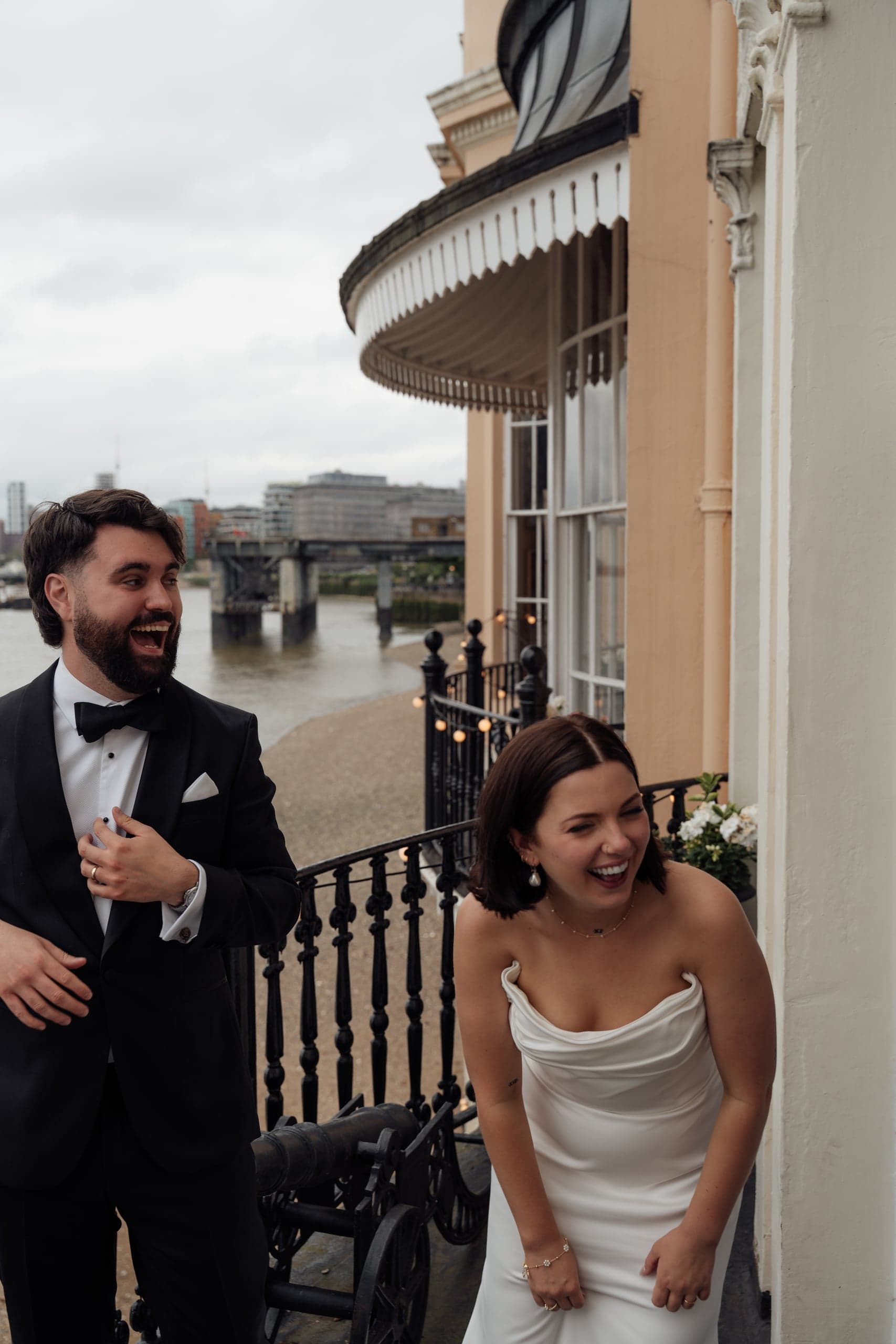Kirsty and Jamie laughing together on a Trafalgar Tavern balcony overlooking Greenwich