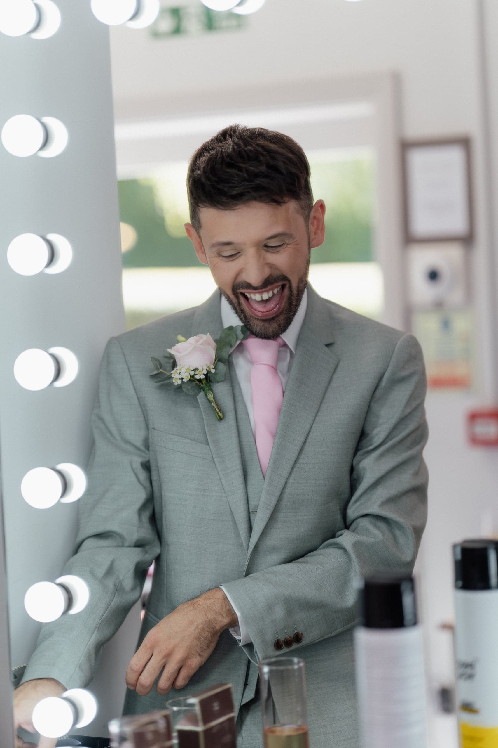 Danny looking in the mirror while getting ready for his wedding at Winters Barns